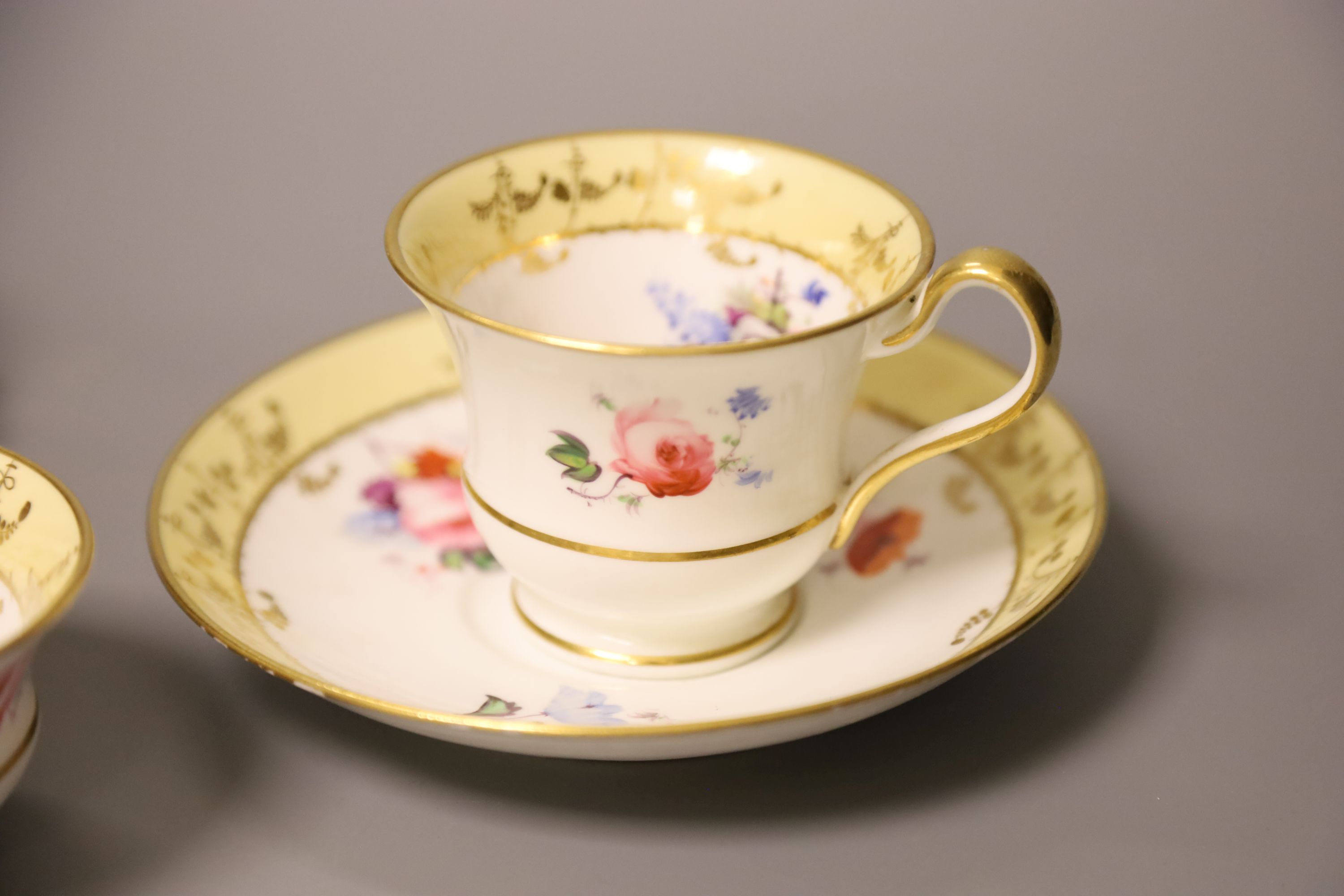A Worcester Flight Barr teacup and saucer with gadroon border gilded with trailing berries on a salmon ground and Graingers Worcester